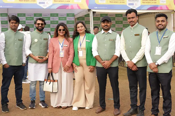 Marathon event organizing team posing together near the medal counter at a city marathon