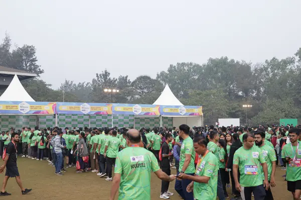 Marathon participants collecting medals at the finish line during a large fitness event in India