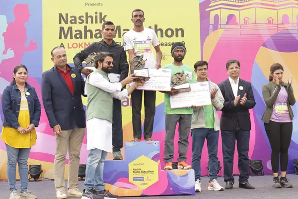 Podium winners receiving trophies and prize cheques at the Nashik Maha Marathon